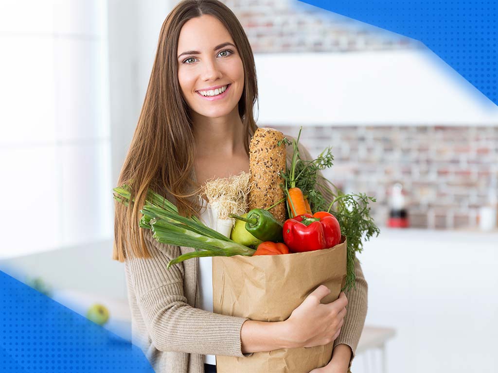 Woman holding shopping: lots of fruits and vegetables. Shopping was definitely done with a list, so saving money is no stranger to her.