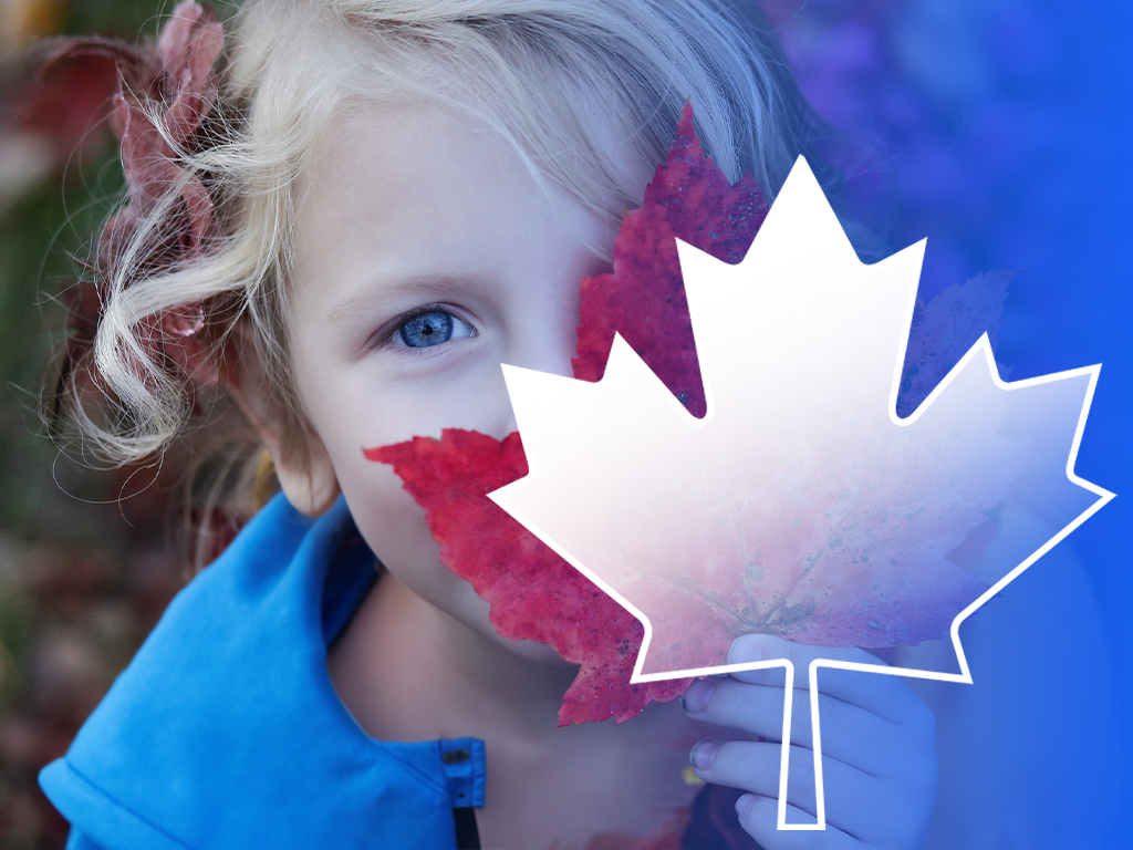 Niño detrás de una hoja de arce con la bandera canadiense.