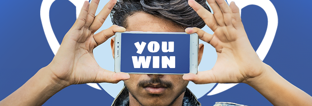 Na obrazku widoczny jest mężczyzna trzymający telefon na wysokości oczu. Na ekranie urządzenia świeci napis "you win". 